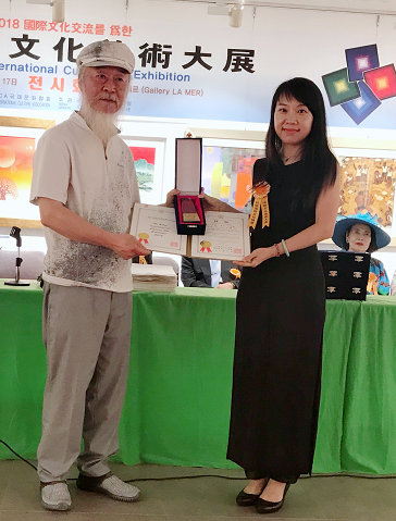 第52回国际文化美术大展上申东权给王晓燕颁奖